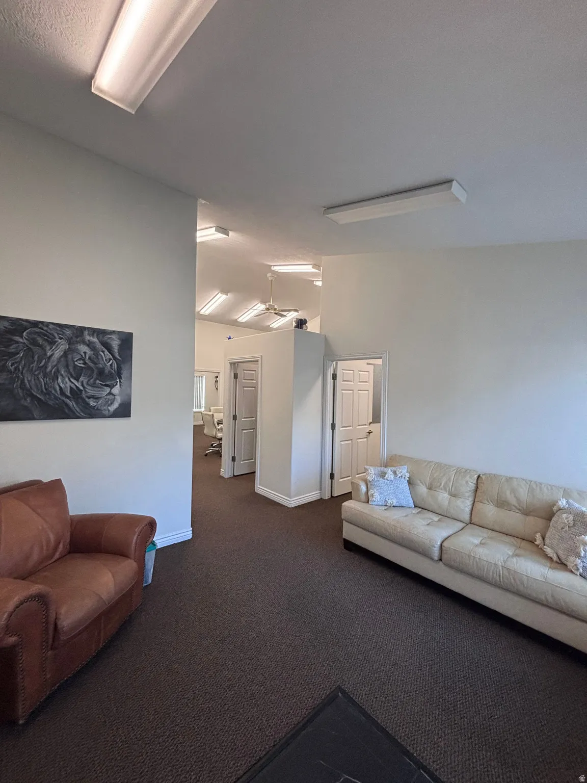 Living area with lofted ceiling and dark carpet