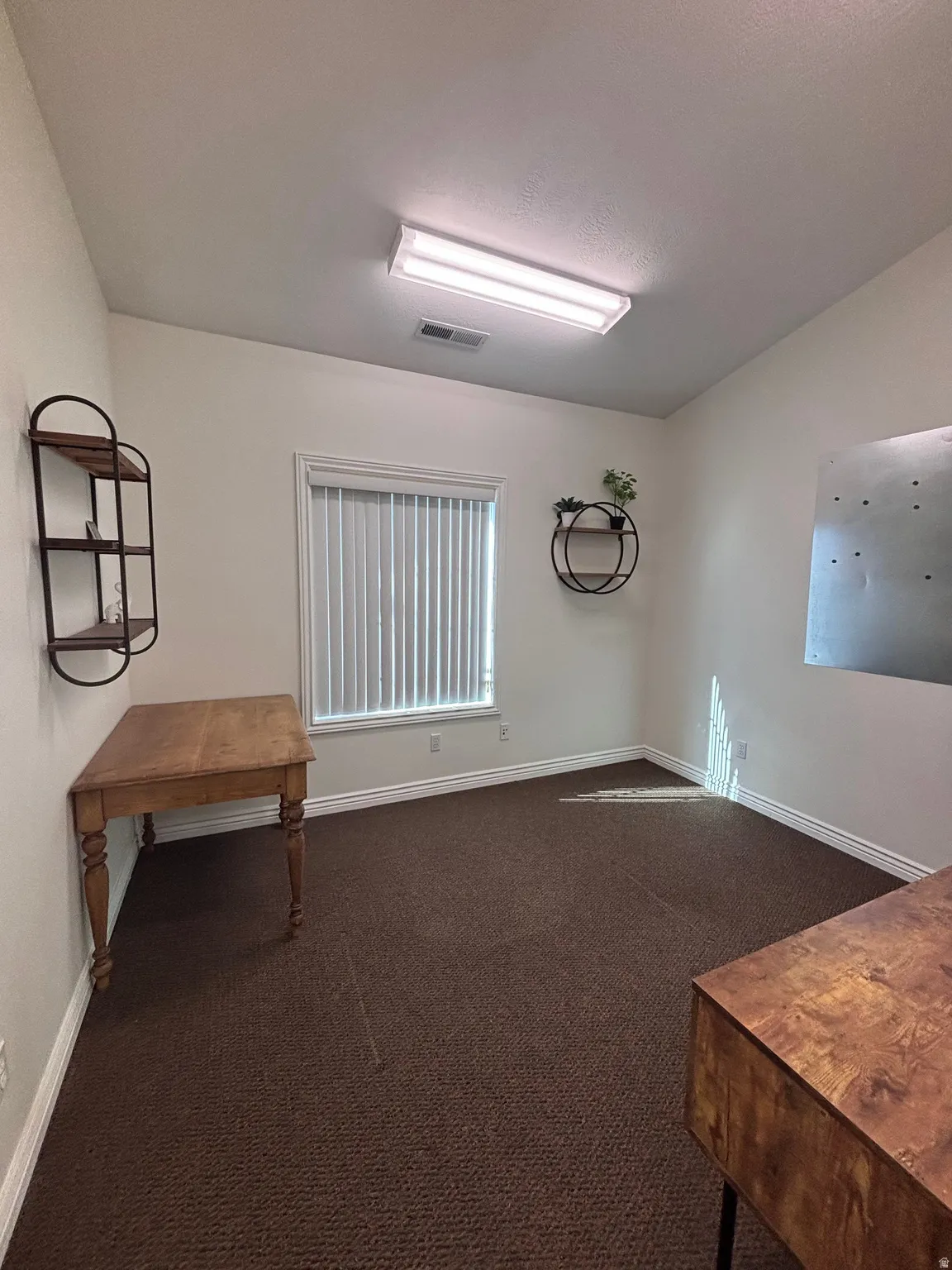 Spare room with dark carpet and electric panel