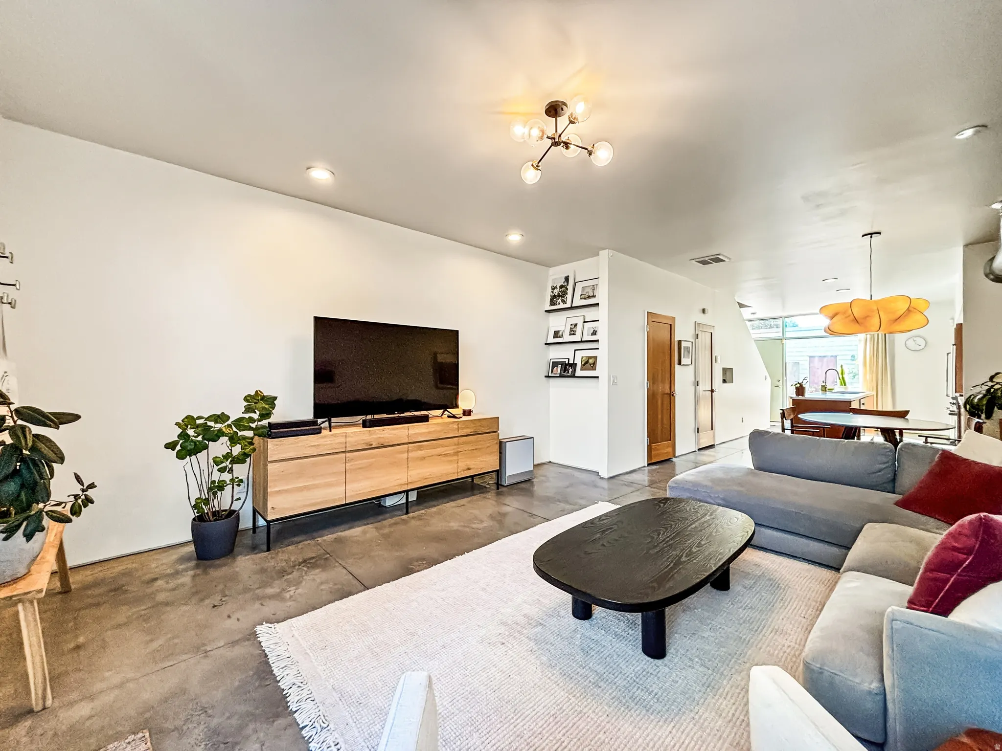 Living area featuring concrete floors and suspended lighting