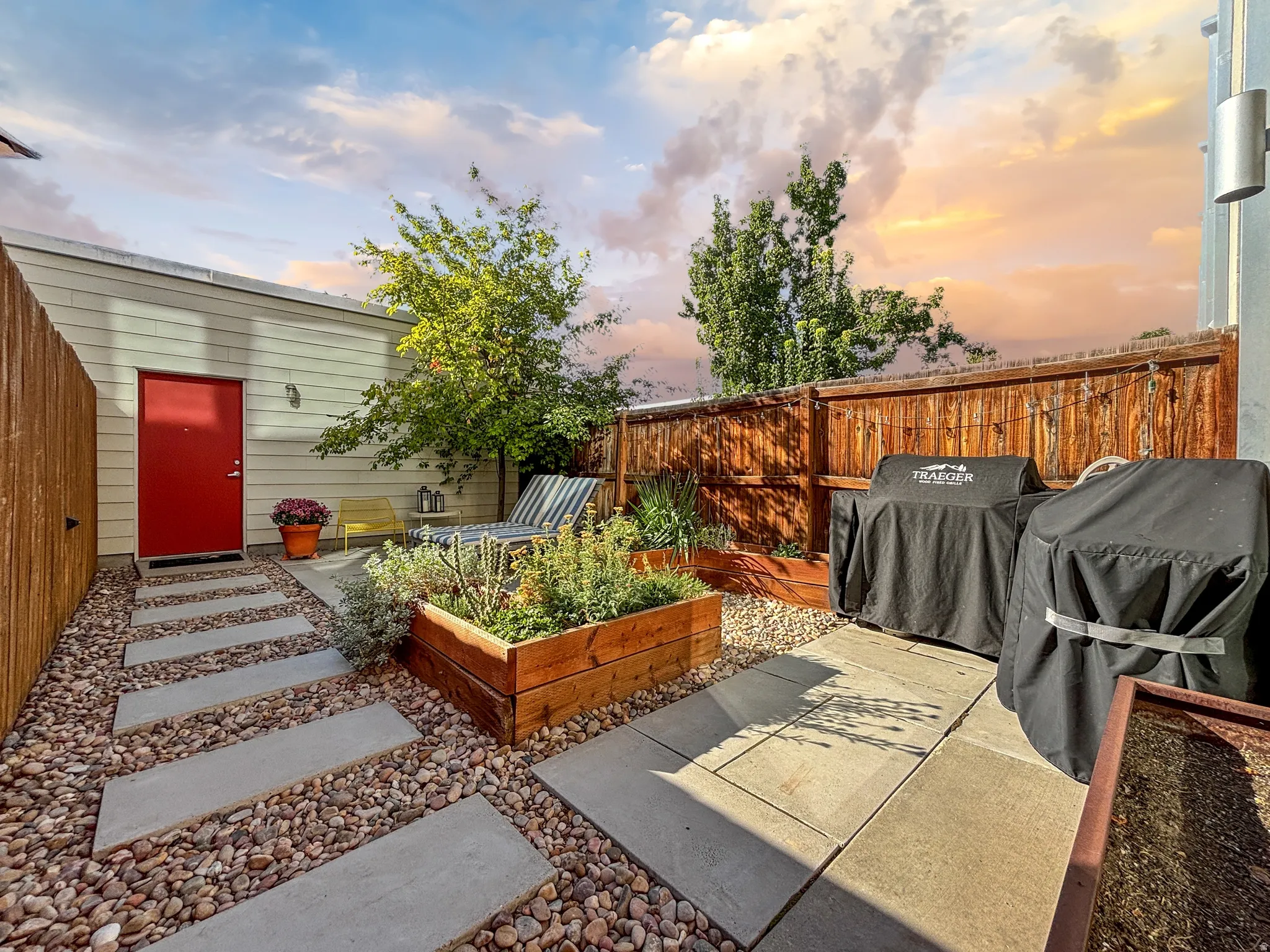Fenced backyard with a garden and a grill