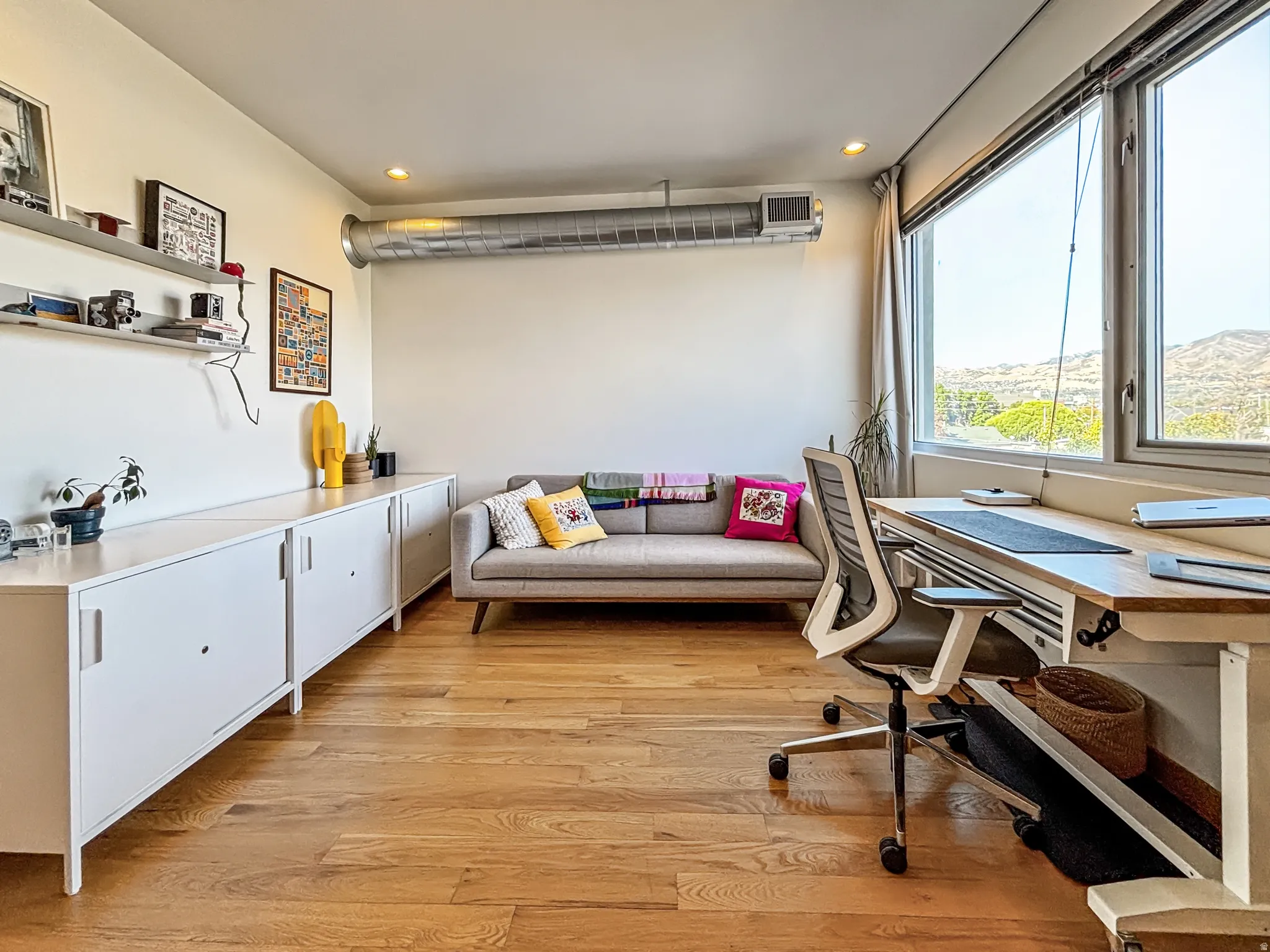 Home office with light wood finished floors and recessed lighting