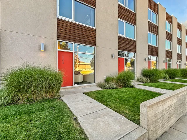 View of exterior entry featuring a lawn and stucco siding