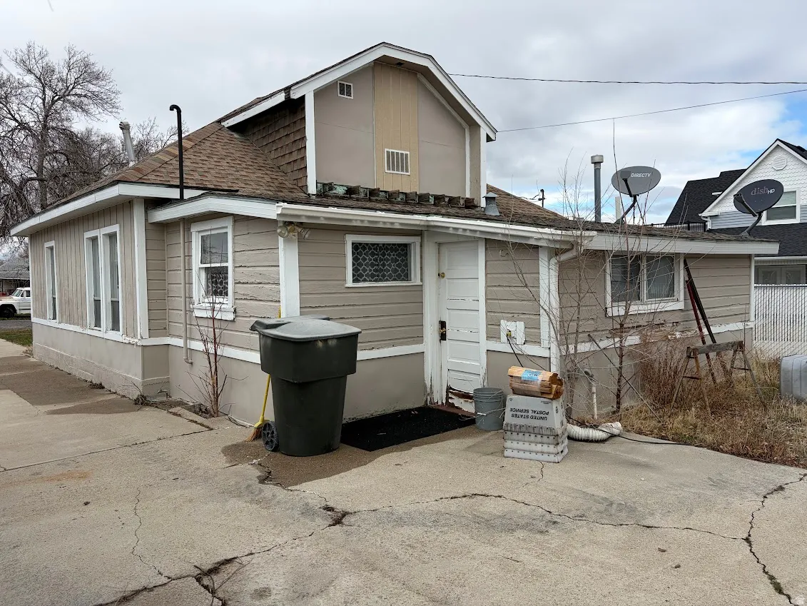Back of house featuring roof with shingles