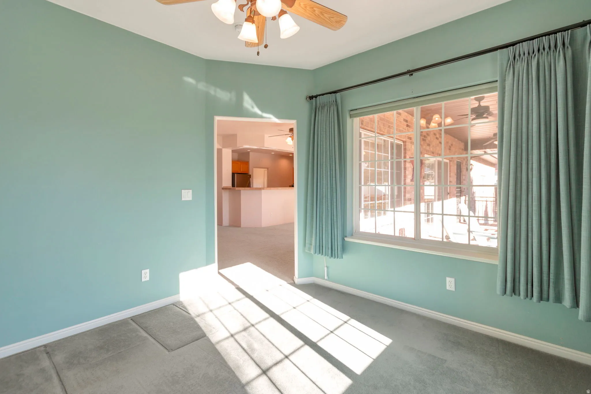 Unfurnished room with a ceiling fan and light carpet