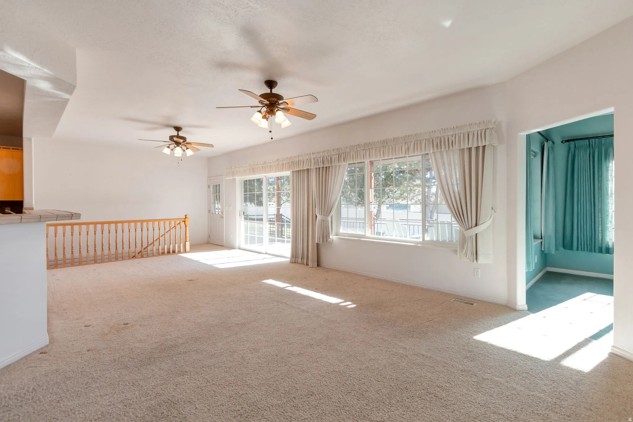 Empty room featuring light carpet and ceiling fan