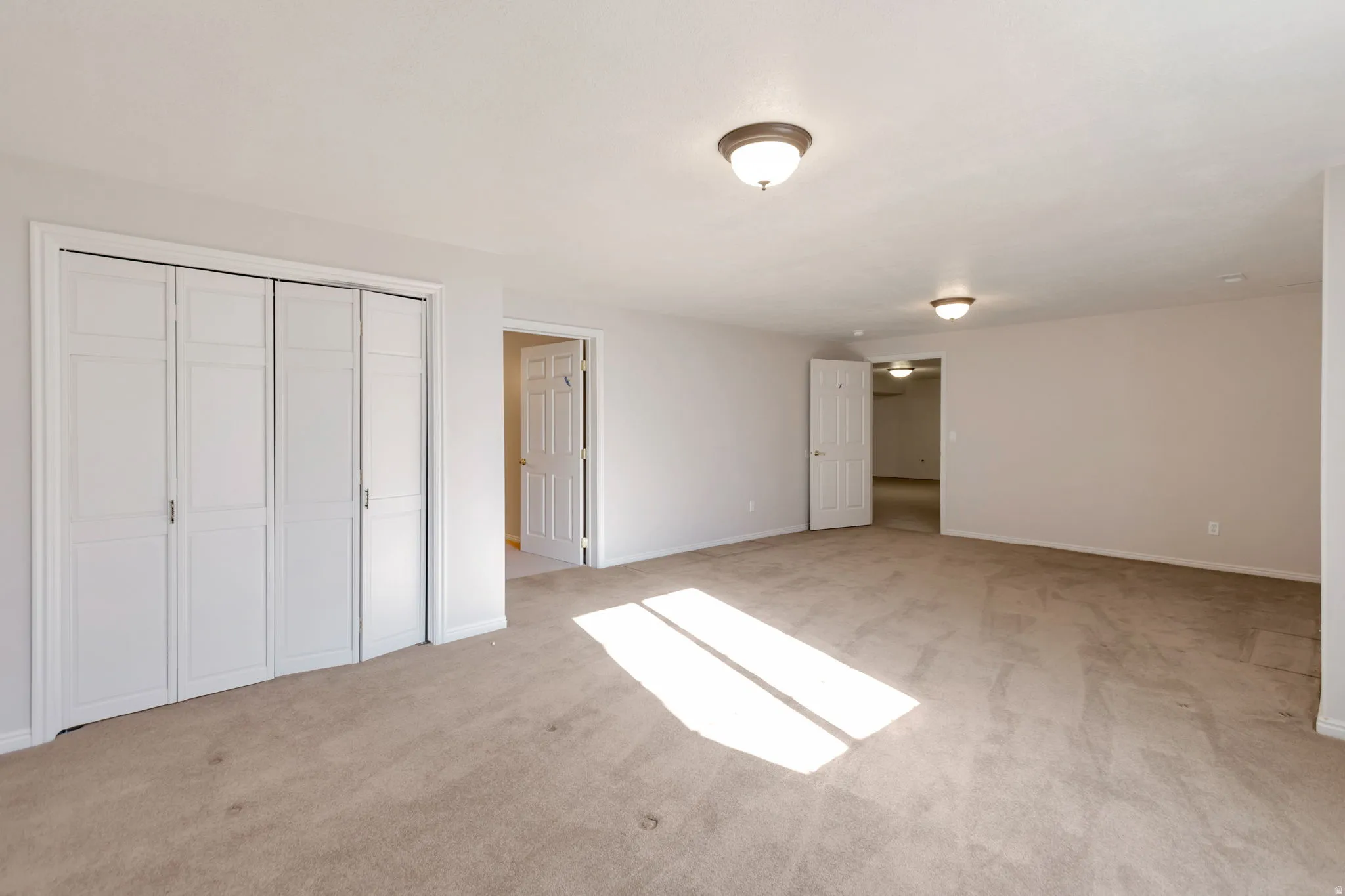 Unfurnished bedroom featuring light carpet and a closet
