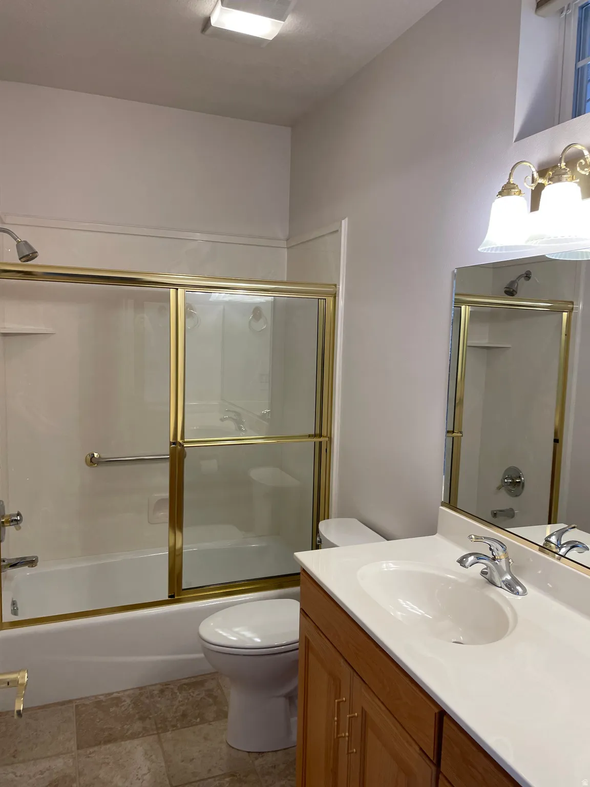 Bathroom featuring a white vanity with an integrated sink, chrome faucet, and wood-finish cabinetry