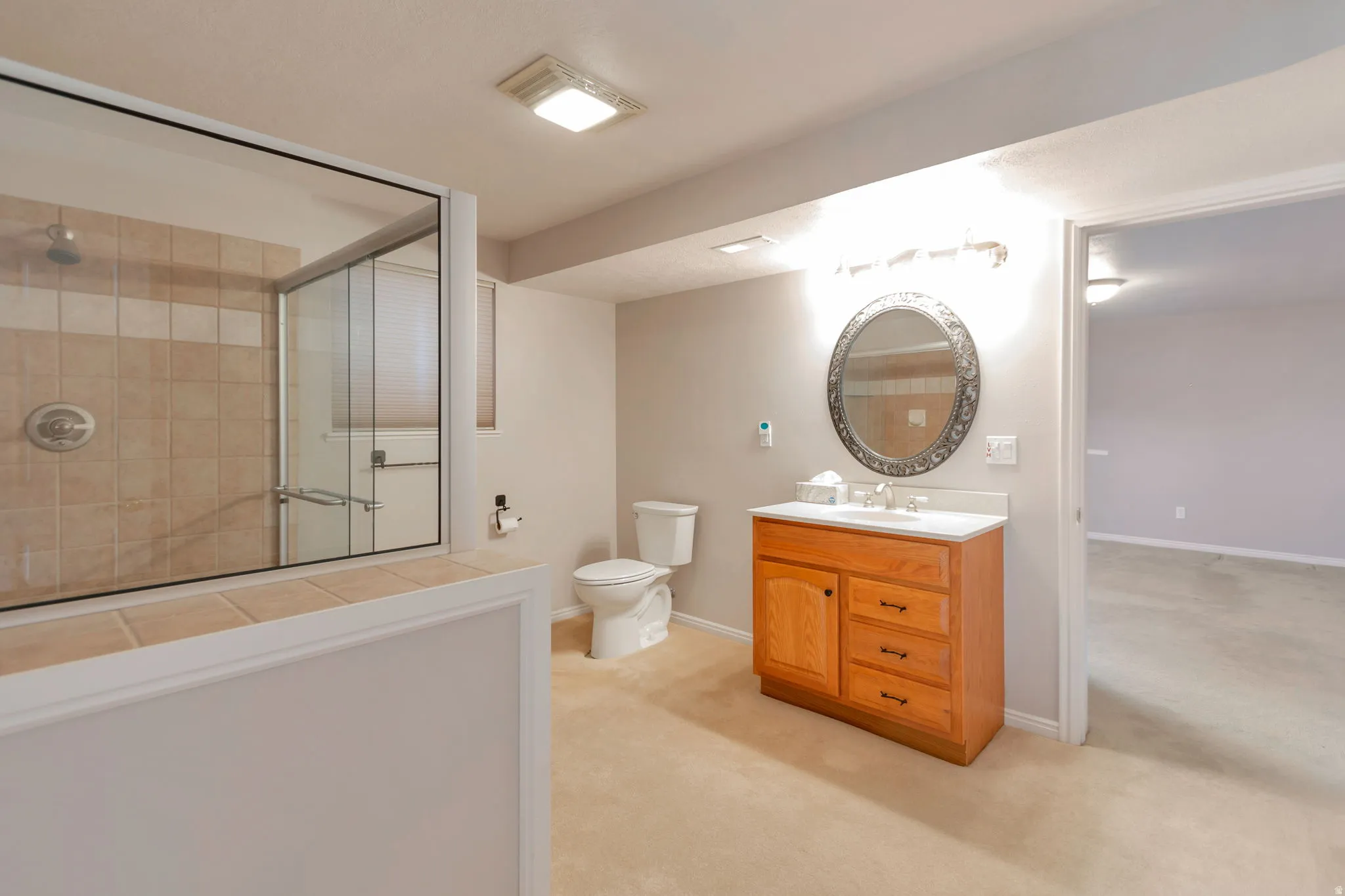 Full bath with vanity, a shower stall, and light carpet