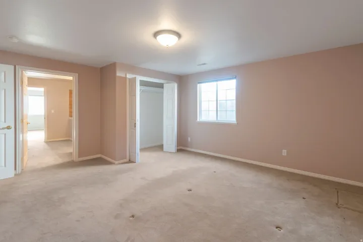 Unfurnished bedroom featuring light carpet and a closet