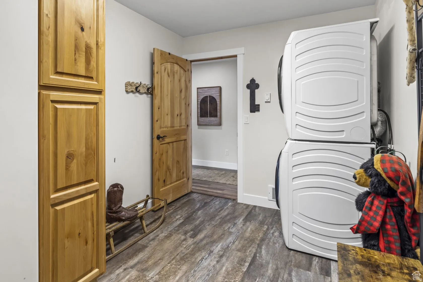 Misc room featuring stacked washer / dryer and dark wood-style floors