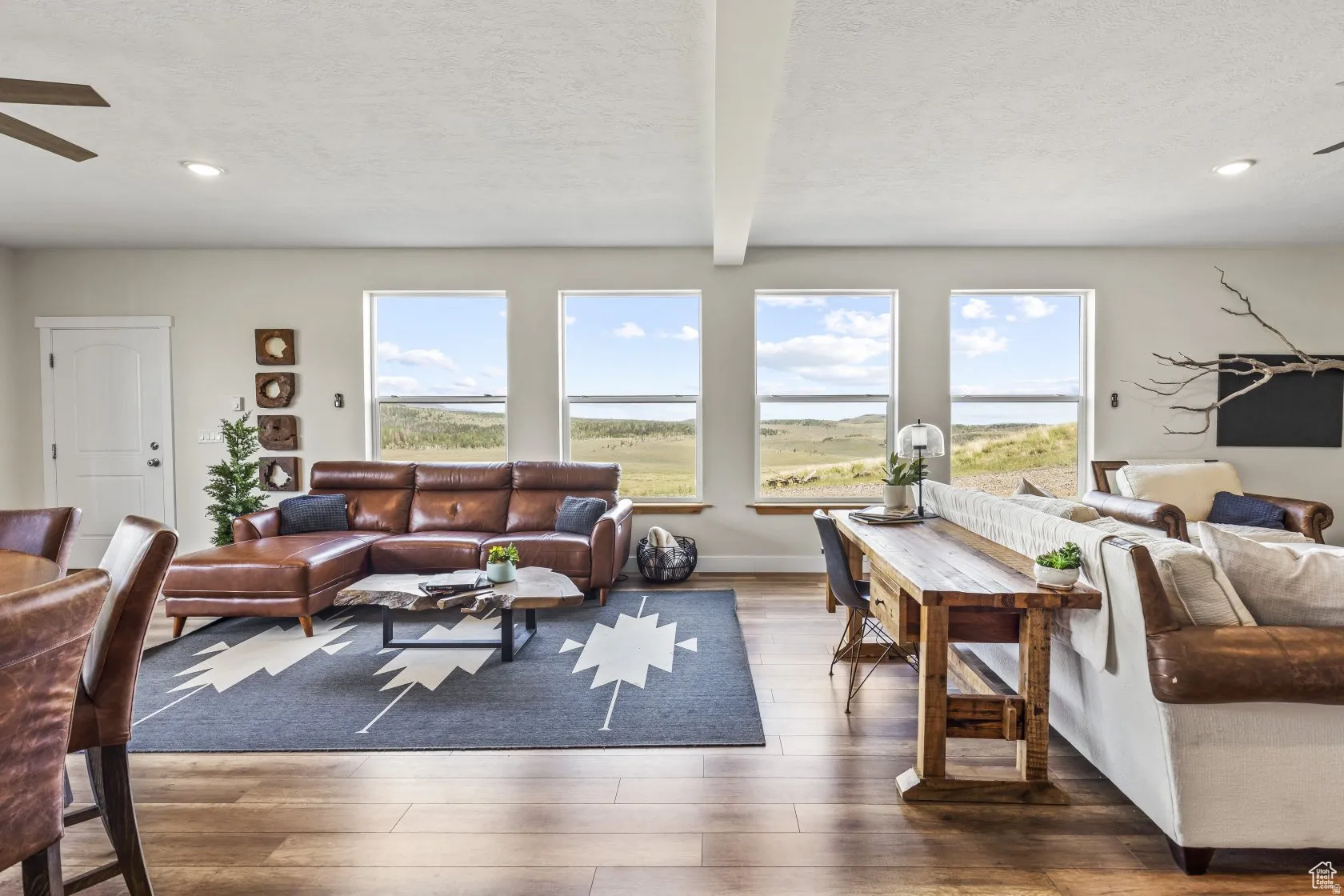 Living area with ceiling fan, a textured ceiling, beamed ceiling, wood-type flooring, and recessed lighting