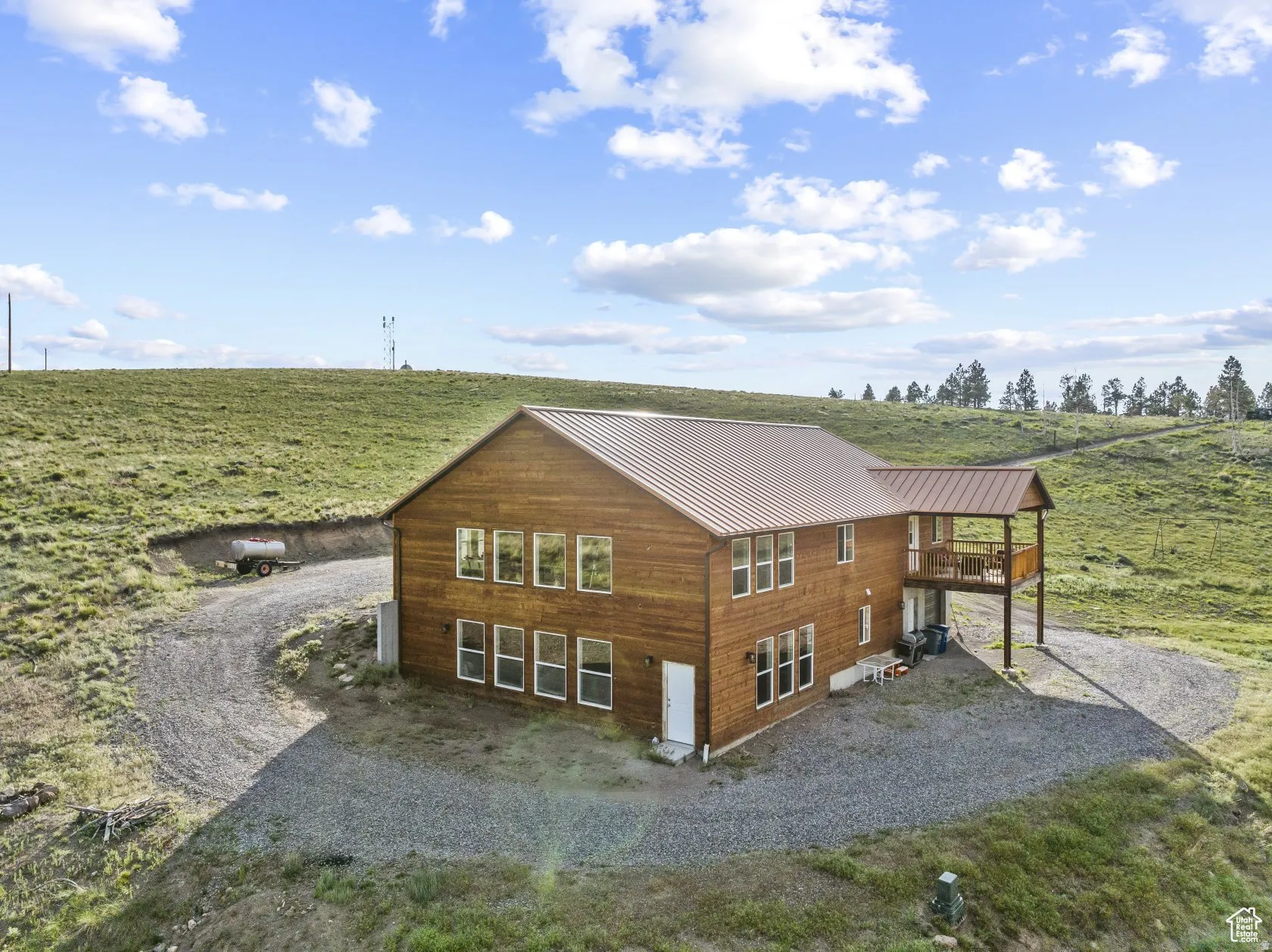 Back of property with a view of rural / pastoral area, a metal roof, and gravel driveway