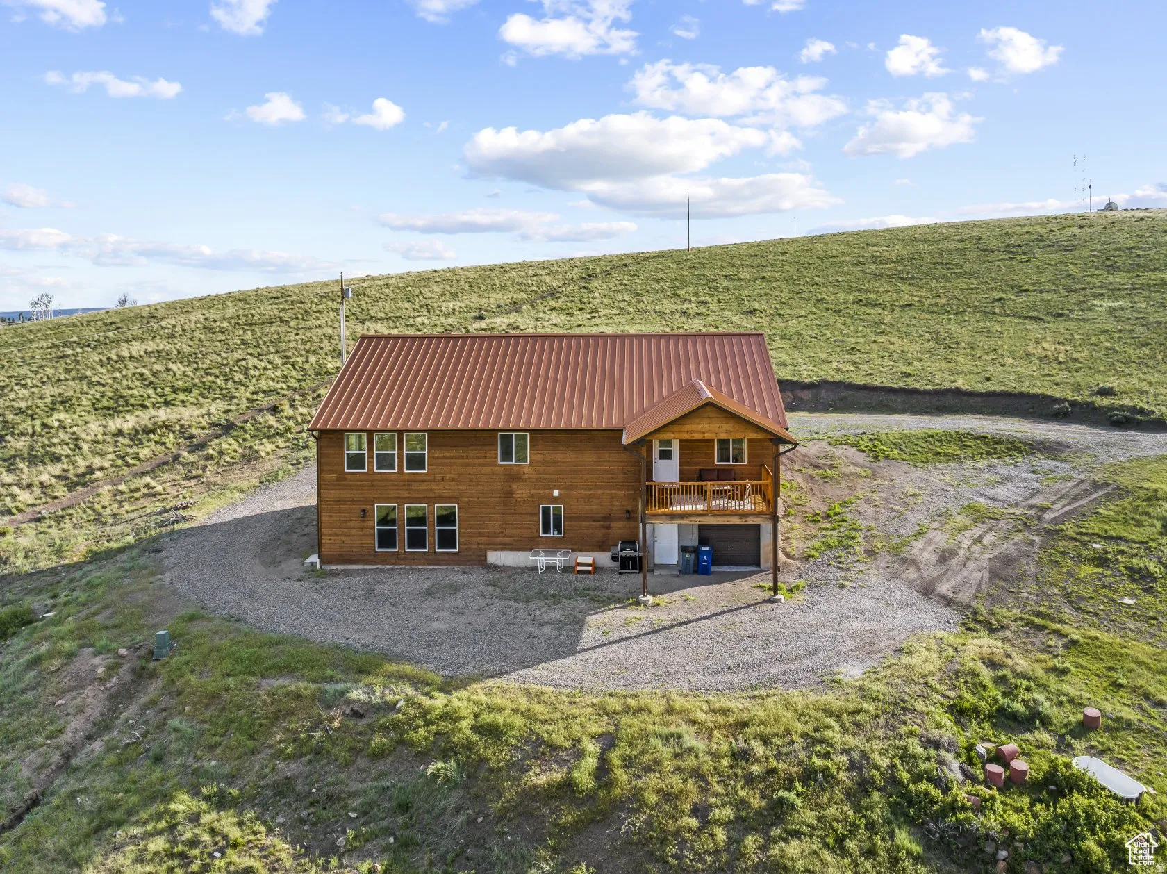 Back of property with a view of rural / pastoral area, agricultural area, a metal roof, a garage, and a patio