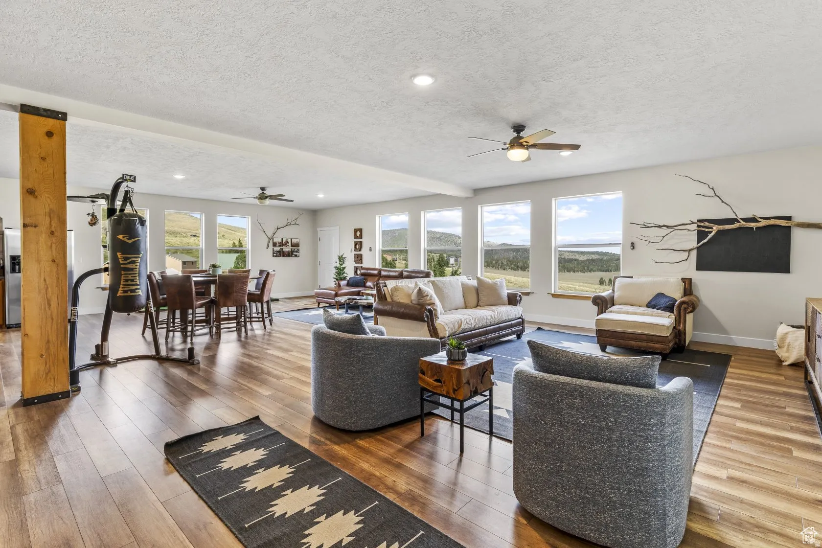 Living area featuring ceiling fan, wood finished floors, a textured ceiling, and recessed lighting