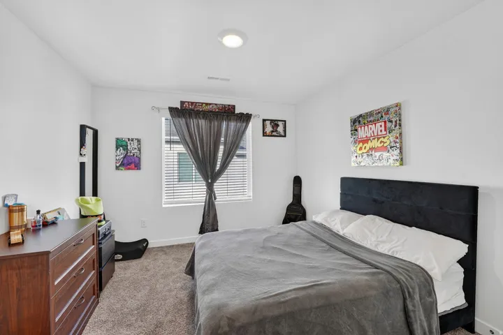 Bedroom featuring dark colored carpet and baseboards