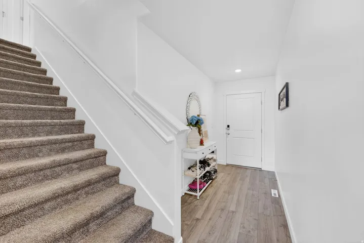 Staircase featuring wood finished floors and recessed lighting