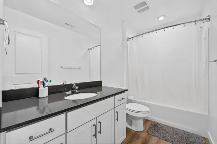 Full bath featuring vanity, light wood-type flooring, and shower / tub combo with curtain