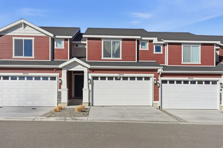 View of front facade with an attached garage, roof with shingles, and driveway