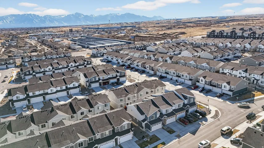 Aerial view of property and surrounding area with a mountainous background and nearby suburban area