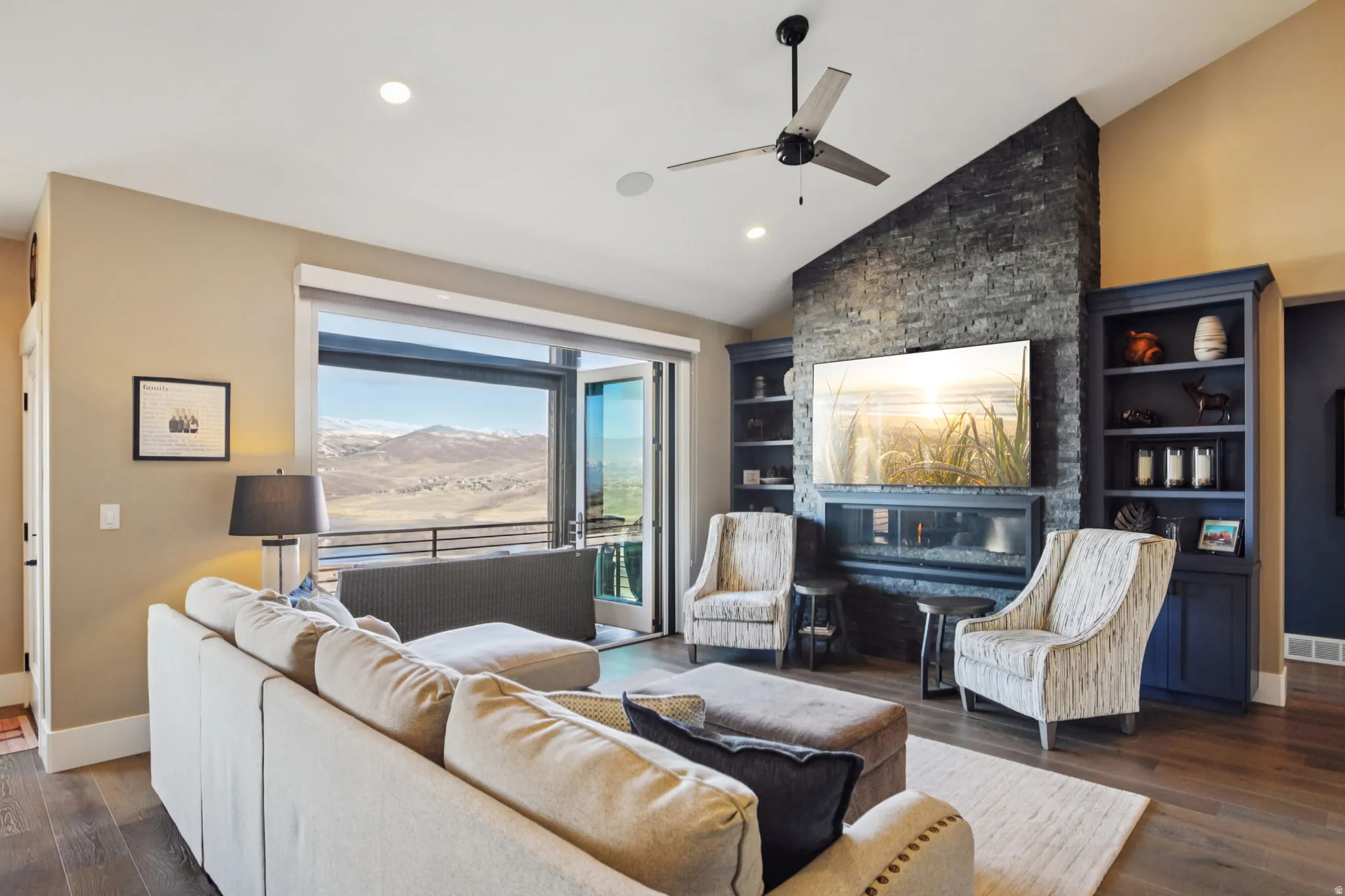 Living room featuring dark wood finished floors, vaulted ceiling, a ceiling fan, and recessed lighting