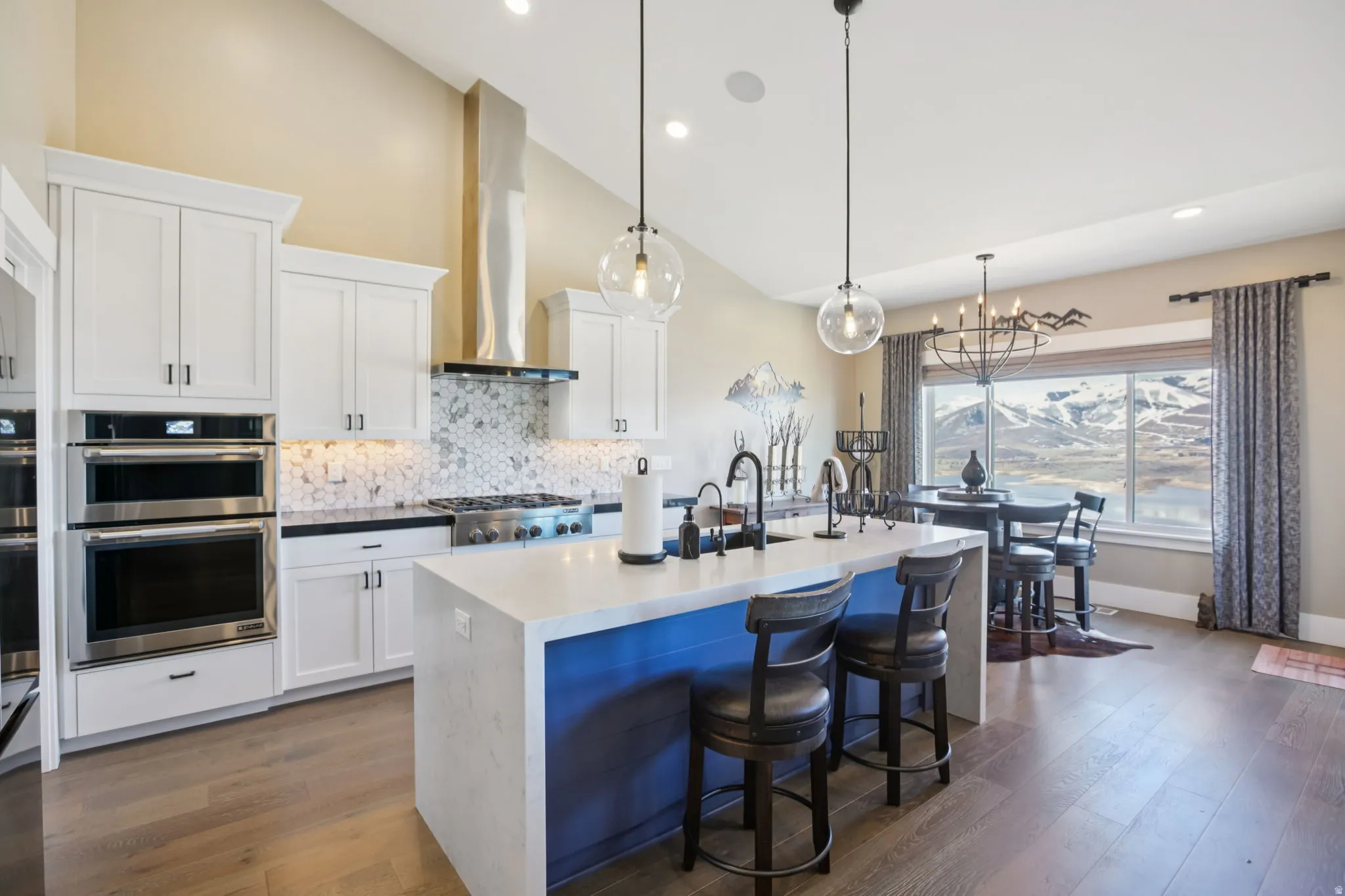 Kitchen featuring white cabinets, tasteful backsplash, dark wood-type flooring, vaulted ceiling, and stainless steel appliances