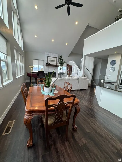 Dining area with dark wood-style flooring, ceiling fan, recessed lighting, and lofted ceiling