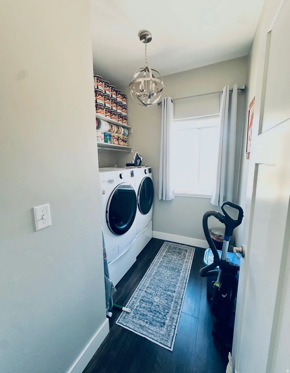 Laundry area featuring washer and clothes dryer, dark wood-style flooring, and hanging lights
