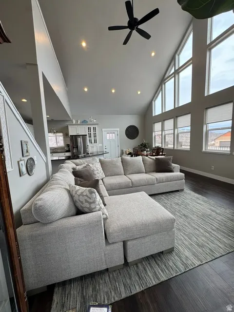 Living area featuring dark wood-style floors, a ceiling fan, recessed lighting, and lofted ceiling