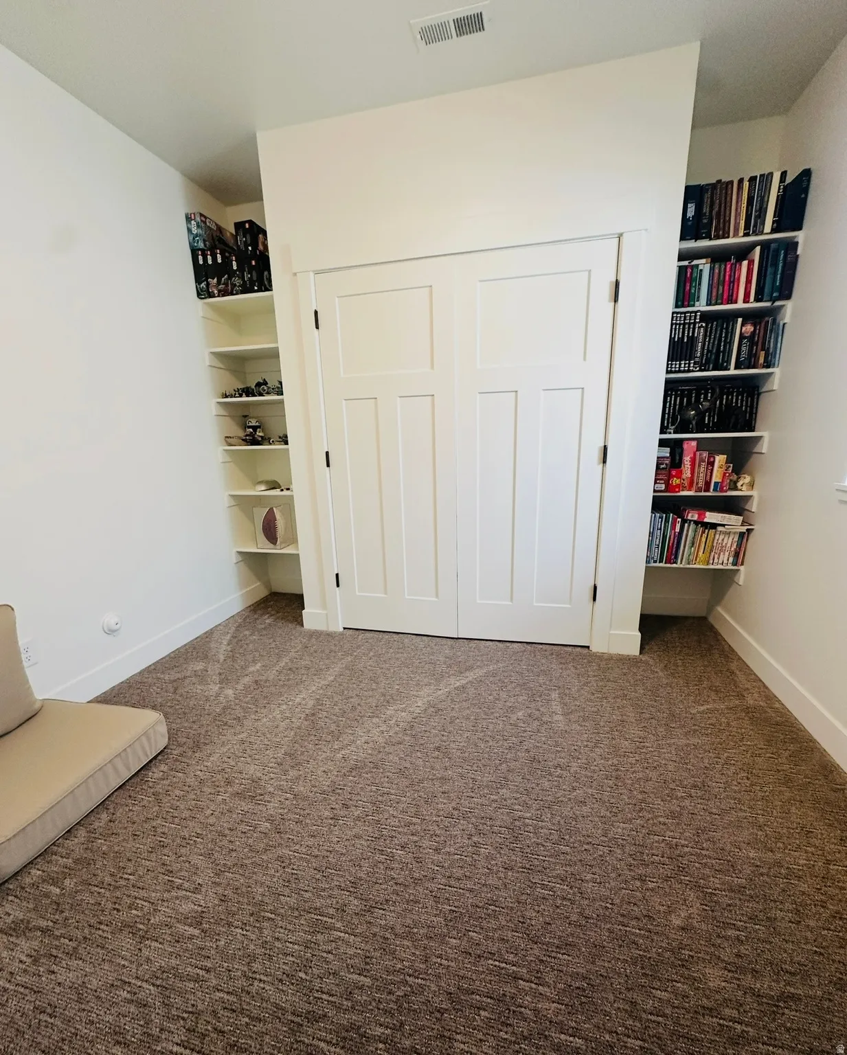 Unfurnished bedroom featuring dark colored carpet and a closet