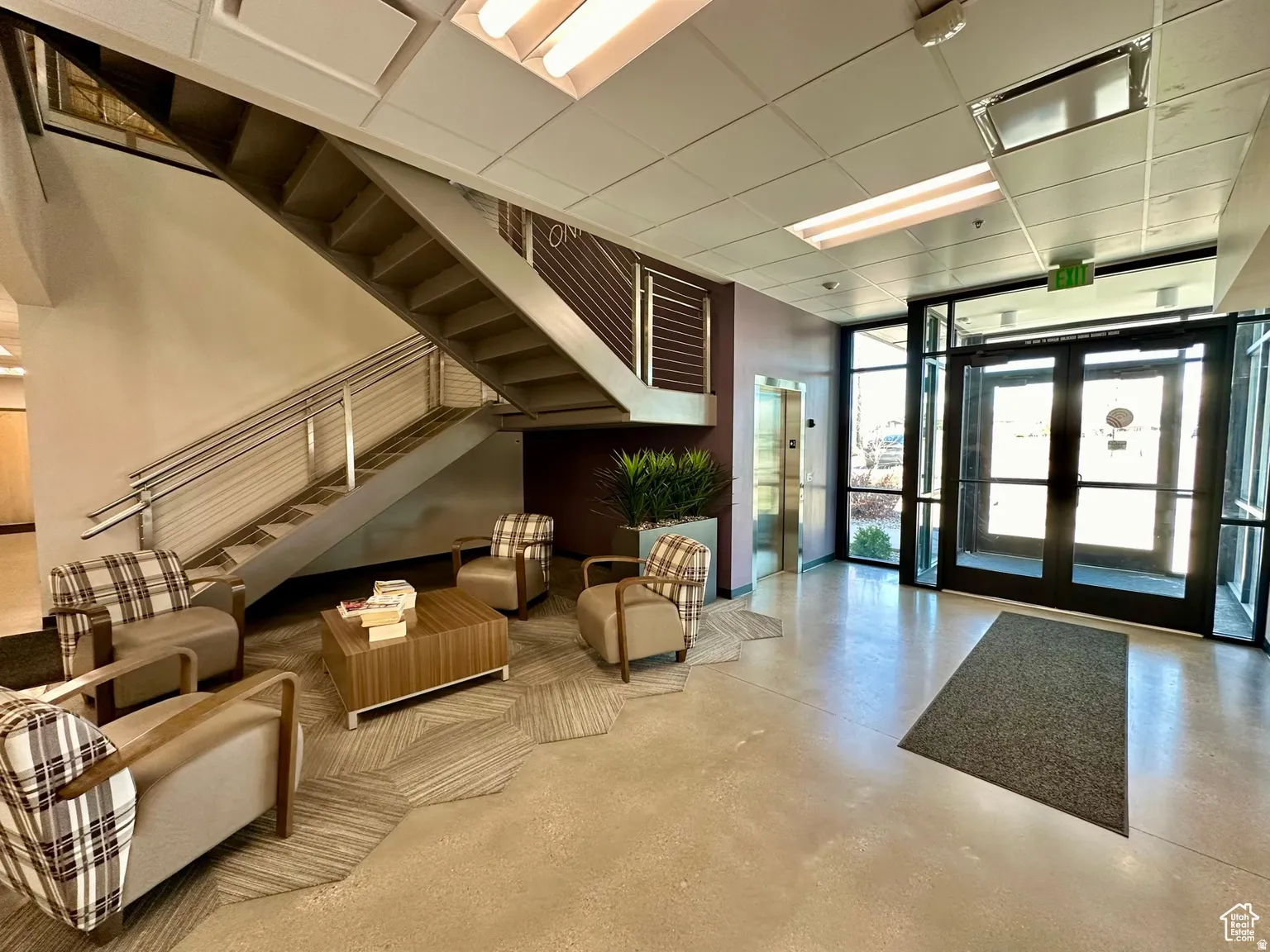 Building lobby with floor to ceiling windows and a paneled ceiling