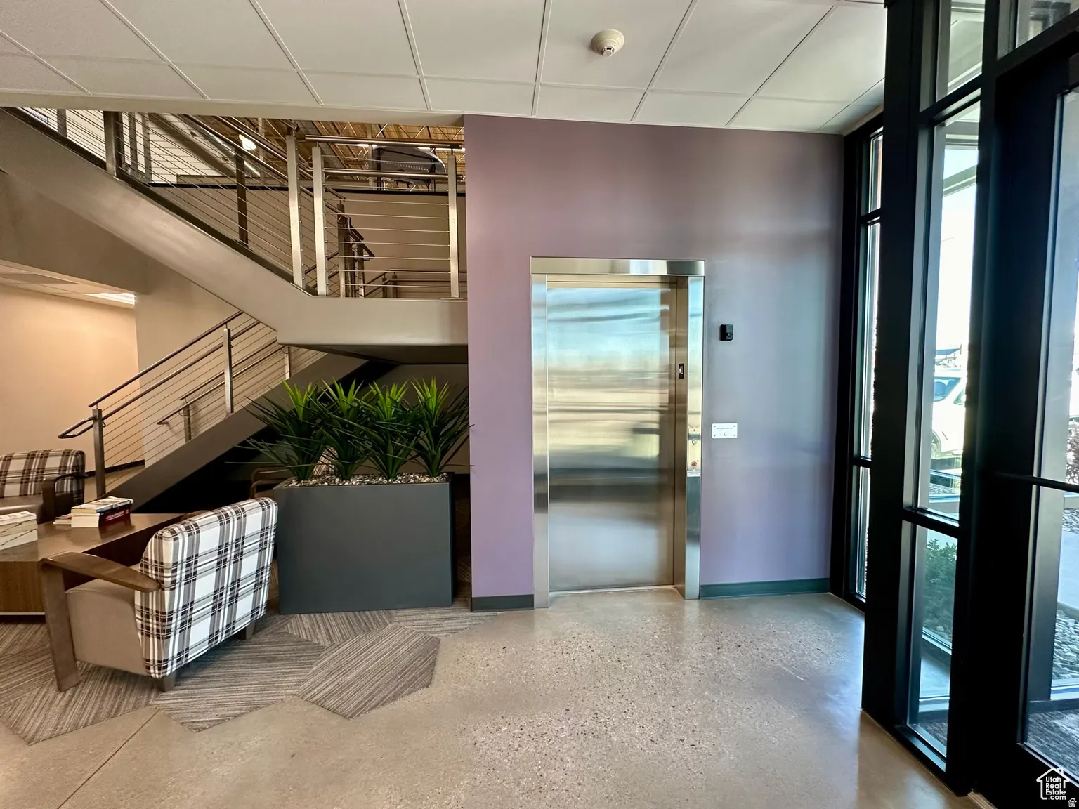 Common area featuring expansive windows and a drop ceiling