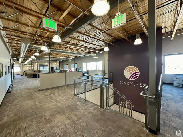 Corridor featuring light colored carpet and wooden ceiling