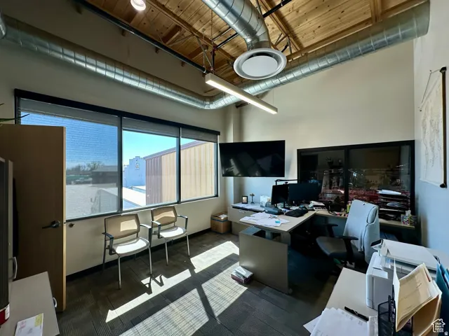 Home office with a high wood ceiling