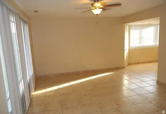 Unfurnished room with a ceiling fan and light tile patterned floors