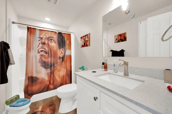 Bathroom featuring vanity, shower / tub combo with curtain, and wood finished floors