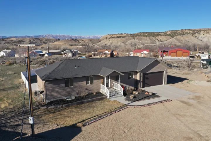 Single story home with driveway, a mountain view, and an attached garage