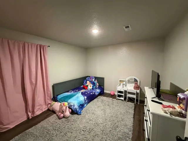 Bedroom featuring dark wood-style floors and a textured ceiling