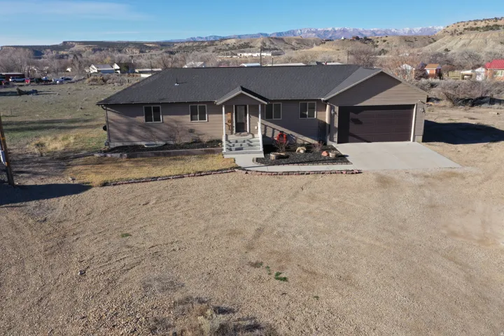 Single story home with driveway, a mountain view, a garage, and a porch