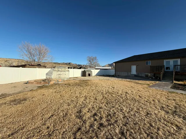 Fenced backyard featuring an outdoor structure