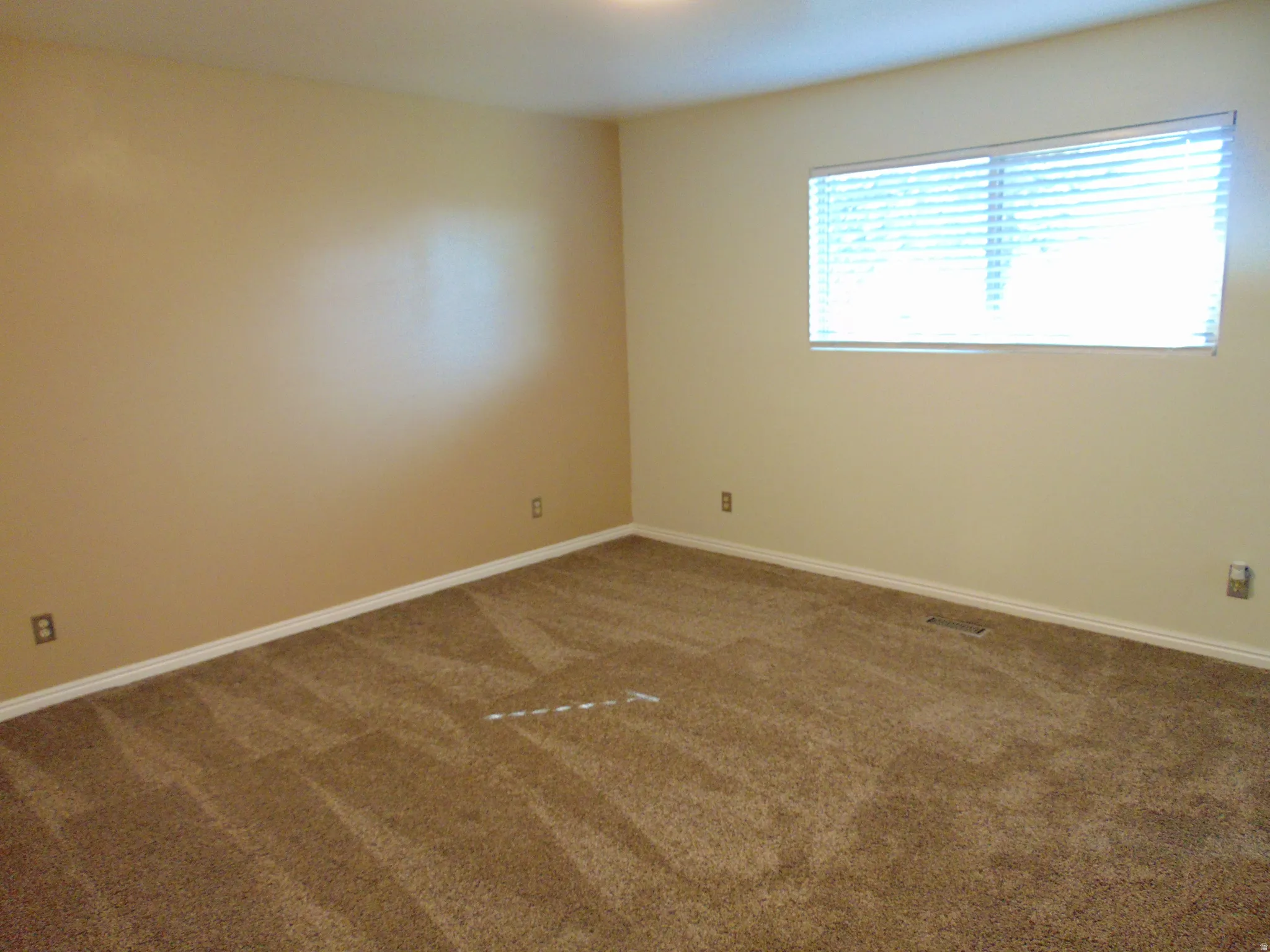 Master bedroom with dark carpet and baseboards