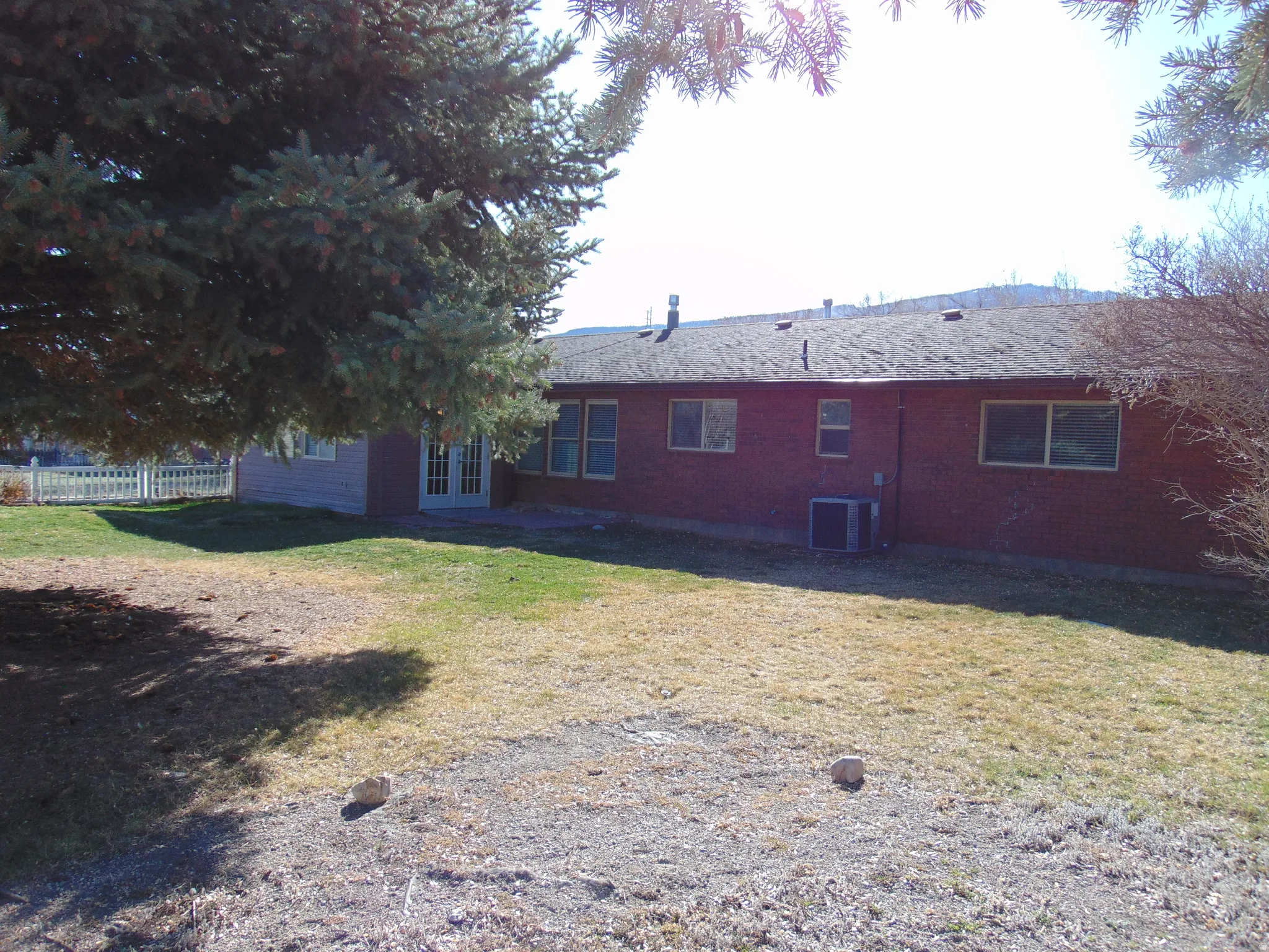 Rear view of house featuring brick siding and french doors
