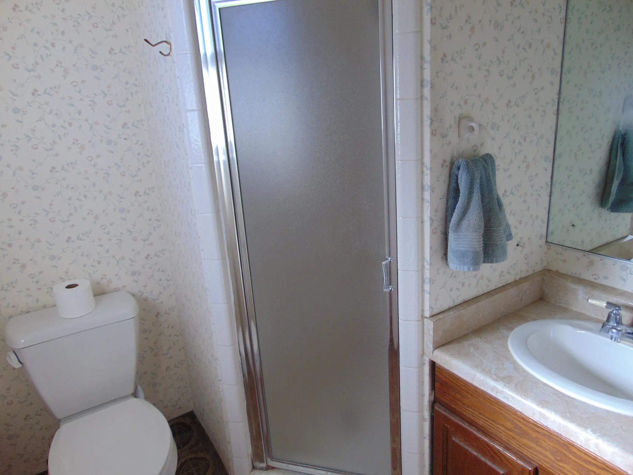 Master Bathroom featuring wallpapered walls, vanity, and a shower stall