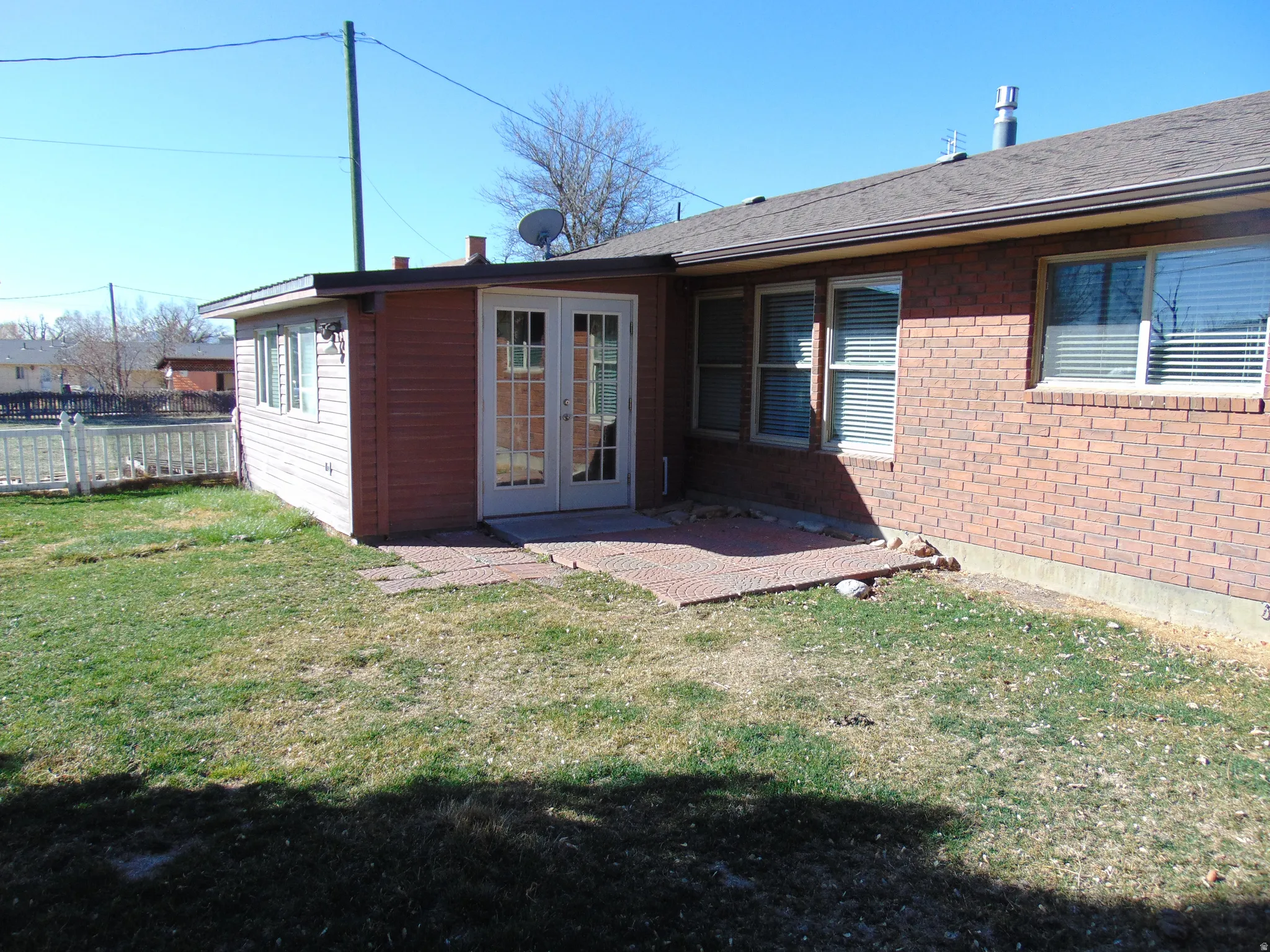 Back of property featuring french doors, a patio area, and brick siding