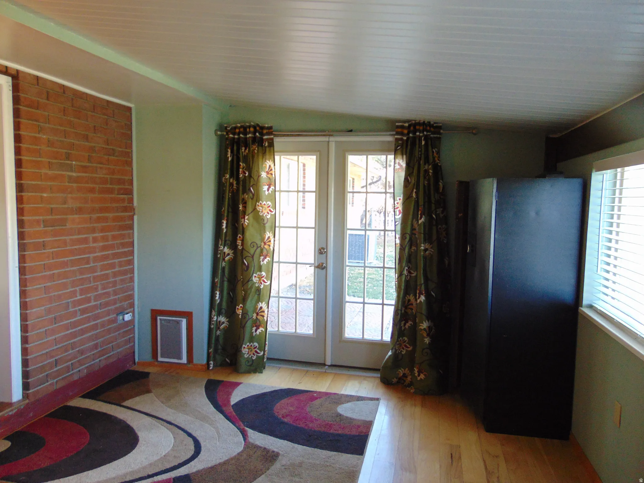 Doorway with french doors, hardwood / wood-style floors, and lofted ceiling