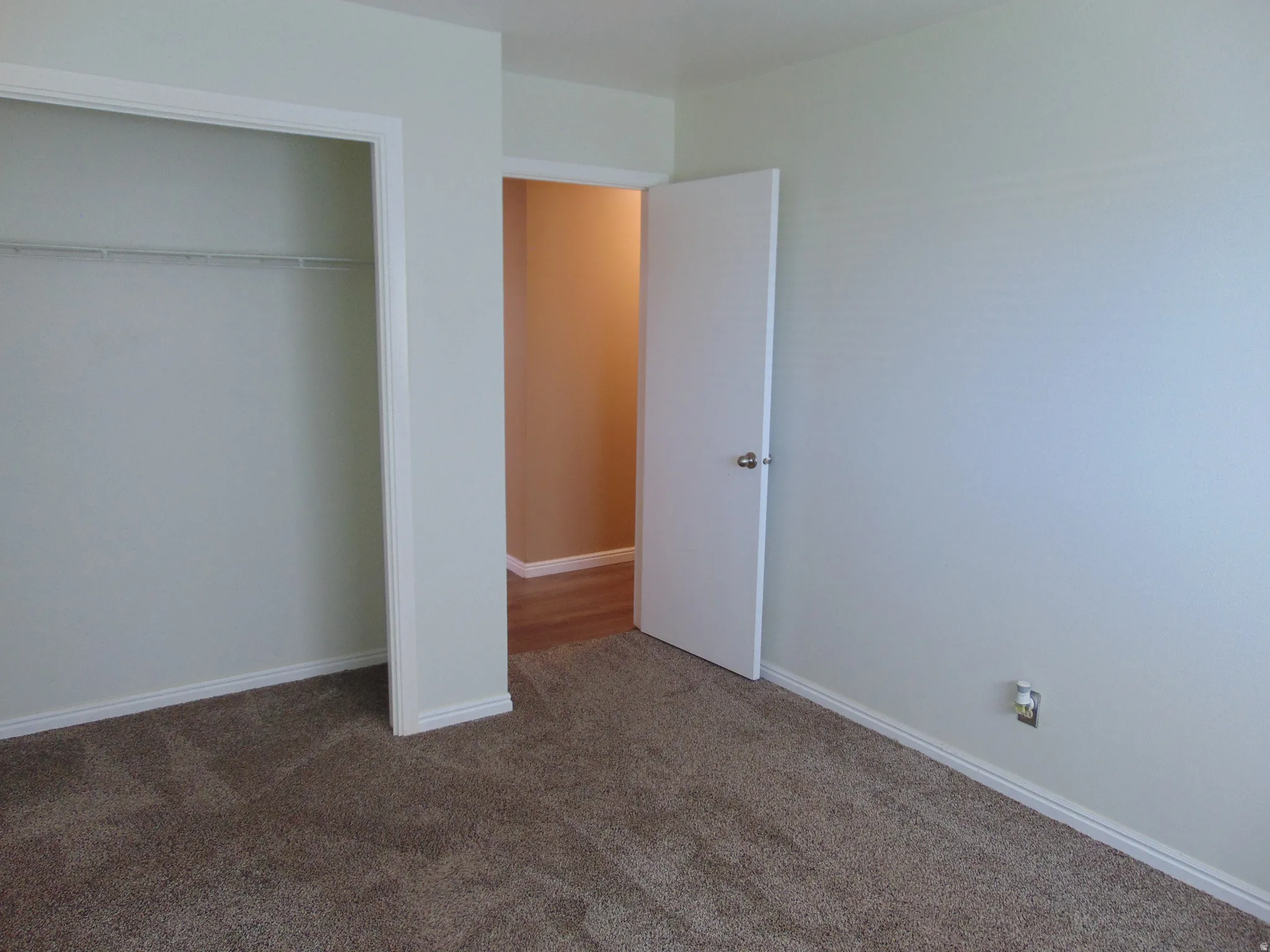 Unfurnished bedroom featuring dark colored carpet and a closet