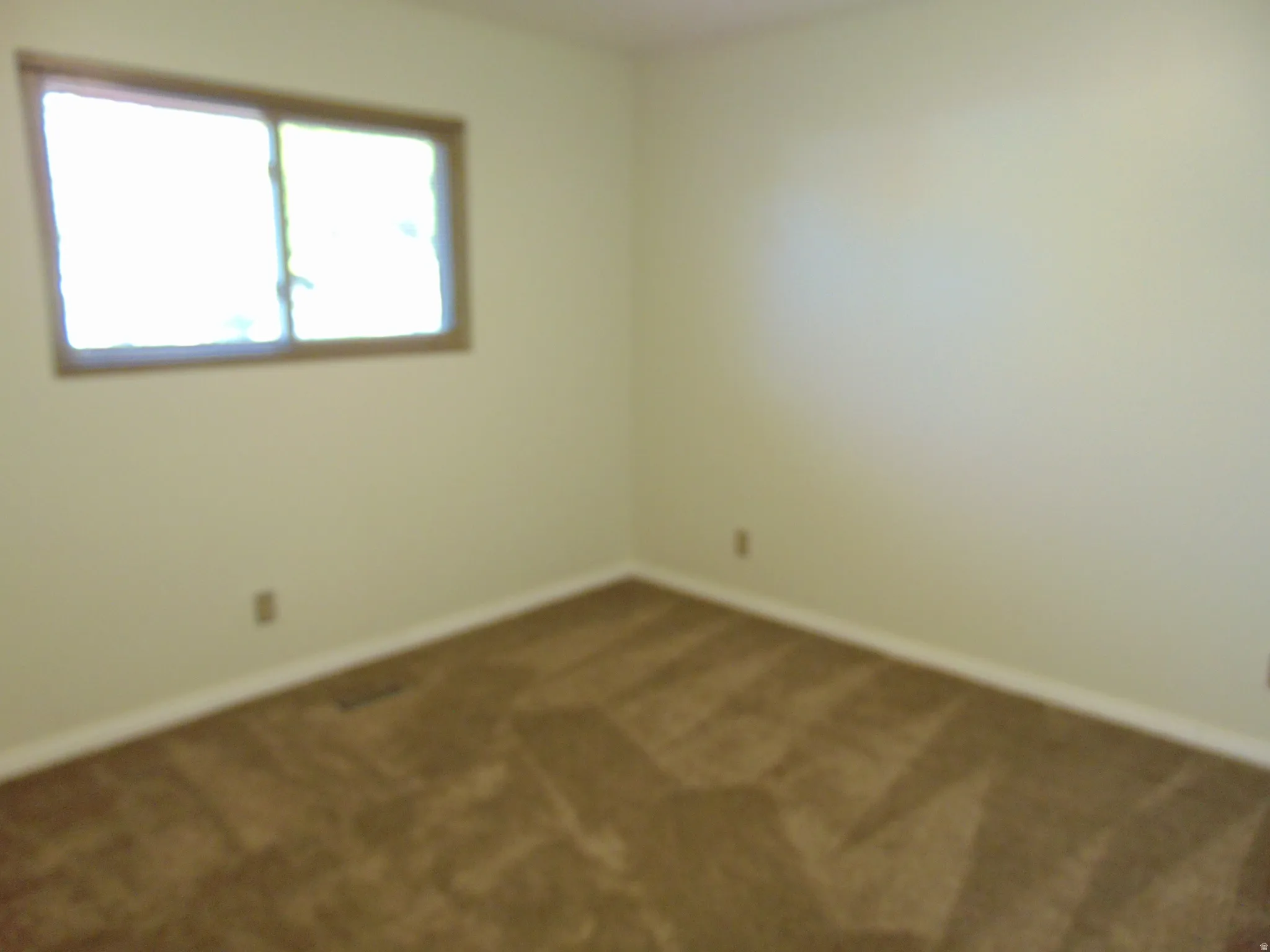 Carpeted empty room with baseboards