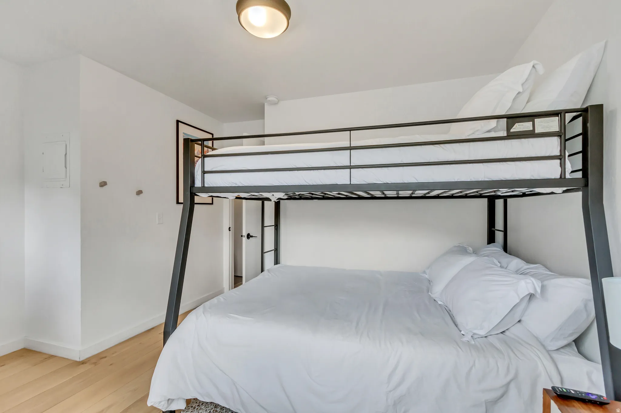 Bedroom with light wood-style floors and electric panel