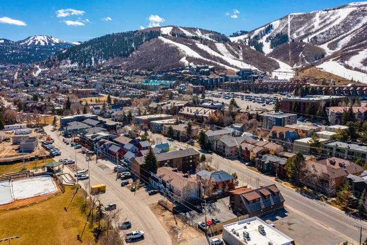 Aerial view of property and surrounding area featuring a mountain backdrop