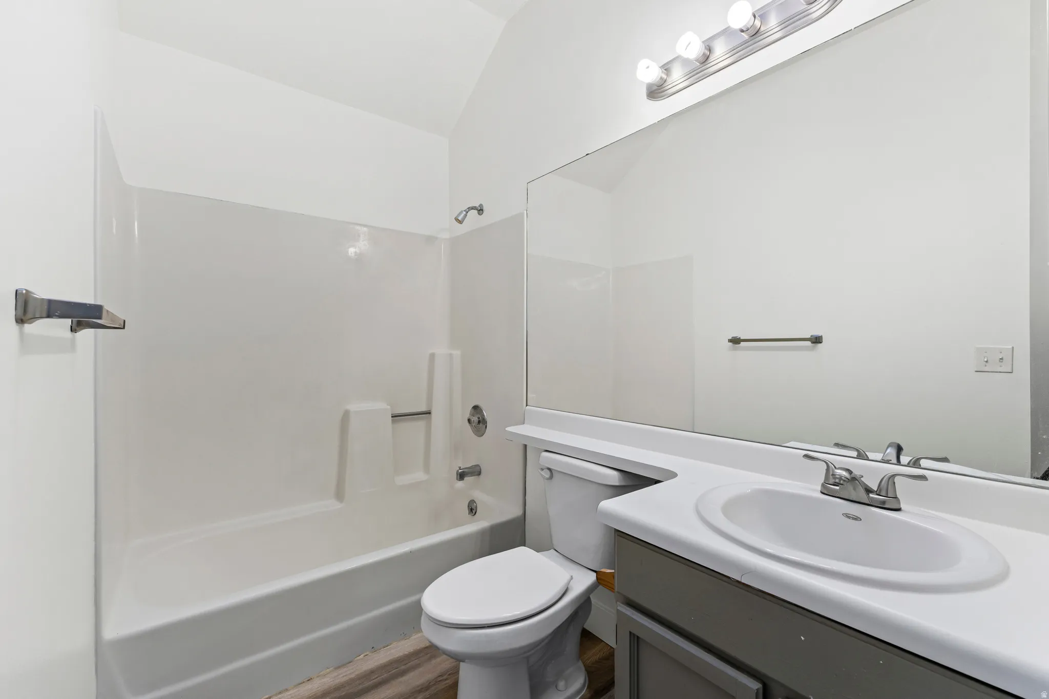 Full bathroom featuring vanity, shower / bathtub combination, and lofted ceiling