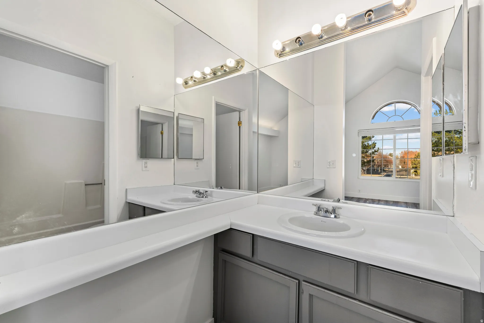 Full bath featuring vanity and lofted ceiling